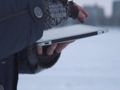 Man Walks Down the Street in Winter and Uses a Tablet Stock Footage 83709849