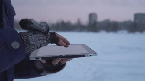 A man walks down the street in winter and uses a tablet Stock Footage 83728799