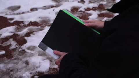 A man walks down the street in winter with documents Stock Footage 225093335