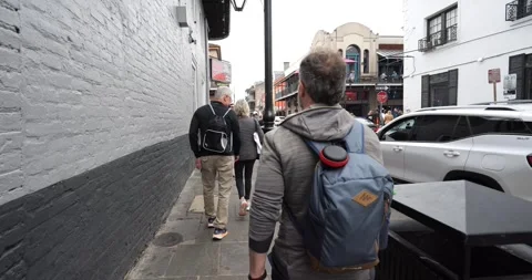 The man walks down the streets of New Orleans, most likely in the French Quarter Stock Footage 268760648