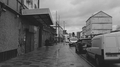 A man walks down a wet sidewalk on a rainy day Video stock 171835567