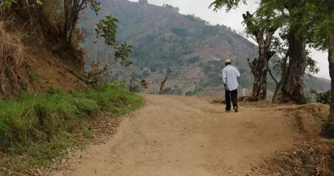 A man walks on a dust road in Uluguru Mt. Tanzania Stock Footage 159349822