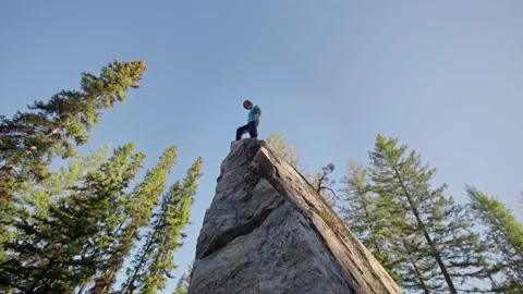 Man walks to the edge of giant boulder in forest, rock climbing, bouldering 库存影片 220306045