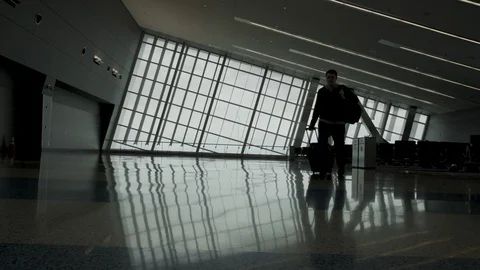 Man walks in an empty airport Stock Footage 129345560