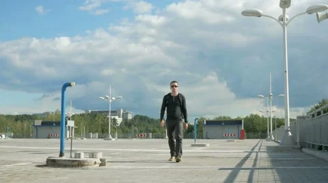 A man walks in an empty parking lot and a message comes in the smart clock Stock Footage 66579105