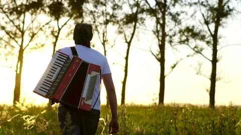 A man walks on a field at sunset Stock Footage 134145886