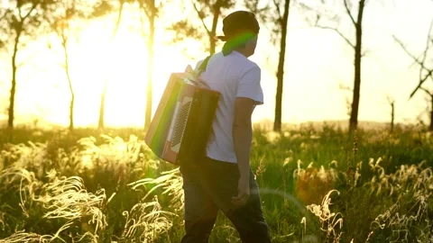 A man walks on a field at sunset 스톡 동영상 134146212