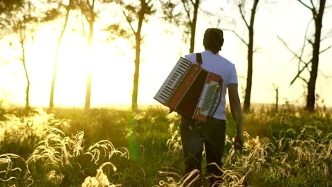 A man walks on a field at sunset 스톡 동영상 134309684