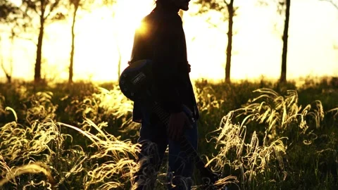 A man walks on a field at sunset Stock Footage 140204560