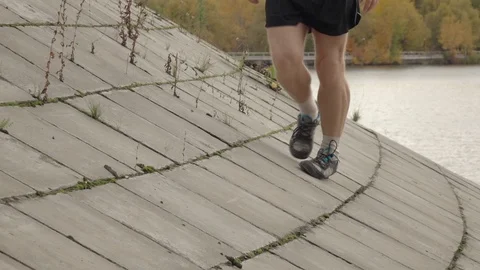 Man walks on flagging downhill. Closeup legs shot in slow motion Vídeos de archivo 122154385