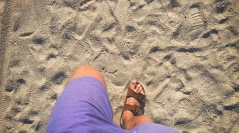 A man walks in flip flops on the sand near the sea Stock Footage 64599634
