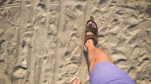 A man walks in flip flops on the sand near the sea Stock Footage 64603162