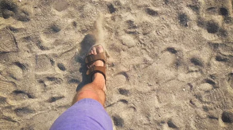 A man walks in flip flops on the sand near the sea Video stock 64603373