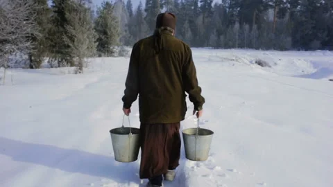 A man walks from a forest spring with buckets of water Stock Footage 104701573