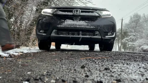Man walks in front of car as it snows Vídeos de archivo 150877635
