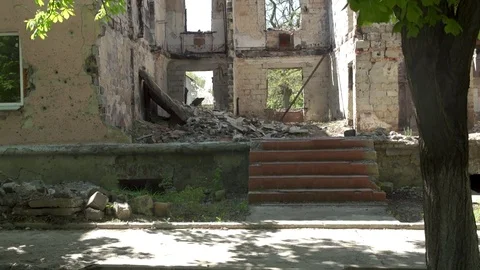 Man walks in front of destroyed building Stock Footage 76963118