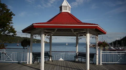 Man walks in front of a red gazebo on the seashore Video stock 63869443