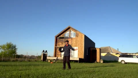 A man walks on the grass in front of his house 4K Video stock 325988423