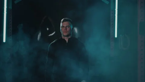 Man walks in gym with fog effect with smoke special effects in dark shades Stock Footage 194046292