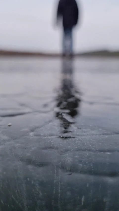 A man walks on ice, reflection of a silhouette of a man on ice Stock Footage 168383514