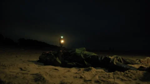 Man walks with a lantern in the dark beach Stock Footage 327980114