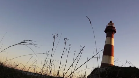 Man walks to lighthouse. silhouette. Super slow Stock Footage 77973994