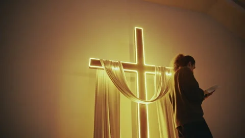 Man Walks Before Luminous Cross Reading Bible Video stock 327207016