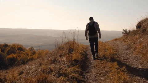 A man walks on a mountain road Stock Footage 118211502