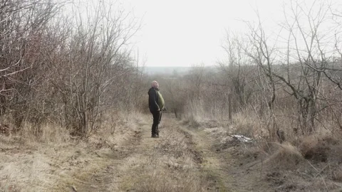 A man walks in nature along the path and takes quince from the grass 스톡 동영상 170484772