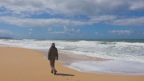 Man Walks on an Ocean Beach Stock Footage 90093711