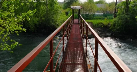 Man walks over bridge over stormy river in first-person video Stock Footage 131143617