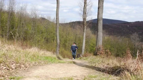 A man walks over rough terrain, is engaged in Nordic walking. Stock Footage 237634504
