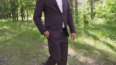 A man walks in the park. Action. Sun shining through green leaves of trees Stock Footage 234086663