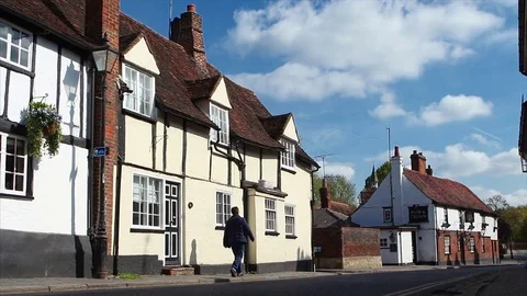 Man walks passed tudor architecture pubs on a sunny Spring day 動画素材 74668799