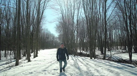 Man walks past camera on snowy trail in the woods Stock Footage 48706327