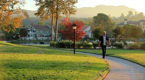 MAN WALKS PATH BY LAKE Video stock 941708