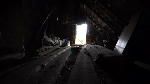 Man walks with pitchfork in a dark attic towards the exit, killer with pitchfork Stock Footage 164875653