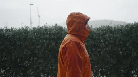 A man walks in the rain and stops to feel it. Stock Footage 328937391