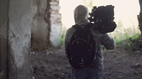 Man walks with an retro camera among the ruins Stock Footage 72101897