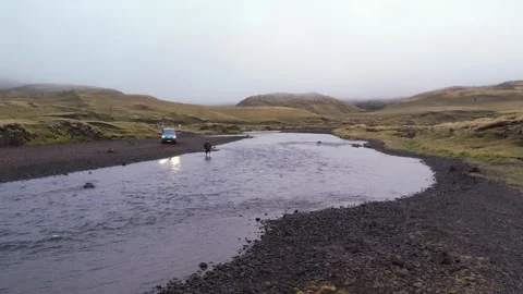 Man Walks into River to Check Water Height Safety for Iceland Water Crossing Stock Footage 258479128
