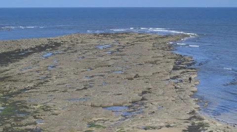 A man walks on a rocky beach. Stock Footage 67826434