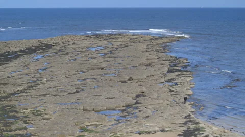 A man walks on a rocky beach. Stock Footage 67826465