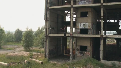 A man walks on a rope at a height on an abandoned construction site. Stock Footage 86348593
