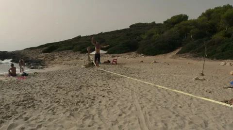 Man walks slackline on Mallorca beach Stock-Footage 43386295