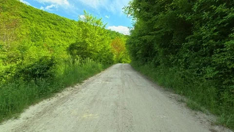 Man walks slowly down a dusty trail. Vrmdza Lake hike. Serbia Stock Footage 338023842