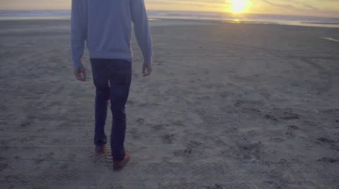 Man walks slowly toward sunset Stock Footage 59902828