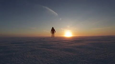 Man walks in the snow at sunset Stock Footage 67421260