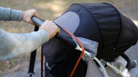 Man walks with a stroller in the park. Caring father for a walk with a child Stock Footage 118690601
