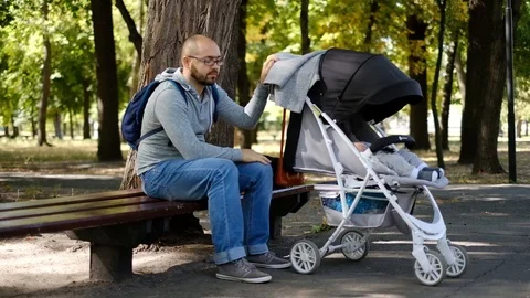 A man walks with a stroller in the park. Stock Footage 118690603