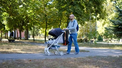 Man walks with a stroller in the park. Stock Footage 118690622